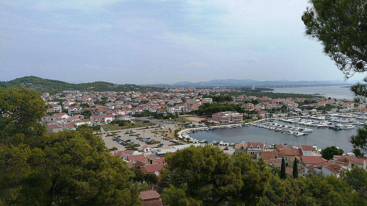 Tribunj fishing village harbor with traditional stone houses and boats in Croatia