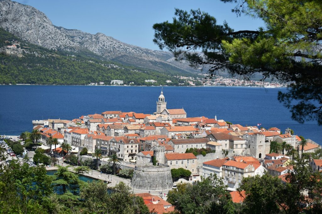 Panoramic view of medieval Korčula town with red terracotta roofs and harbour, closest provisioning point to Proizd Island